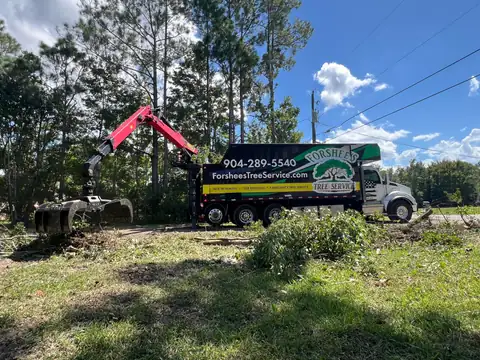 Forshee's Tree Service Kenworth T880 grapple truck loading logs and brush from a cleared lot